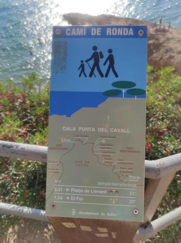 a sign on a fence next to the water at Paradise Village Port Aventuras in Salou
