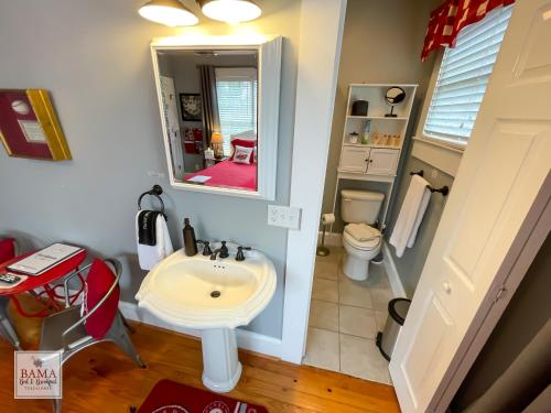 Bama Bed and Breakfast - Sweet Home Alabama Suite في توسكالوسا: حمام مع حوض ومرحاض ومرآة