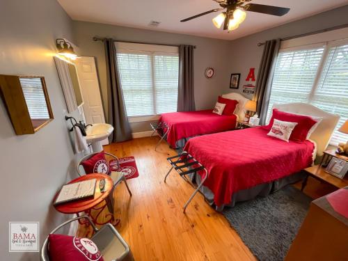 1 dormitorio con 2 camas, mesa y ventilador en Bama Bed and Breakfast - Sweet Home Alabama Suite, en Tuscaloosa