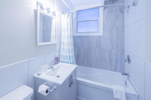 a white bathroom with a sink and a toilet and a window at Boutique Suite #3 in Blue Mountains