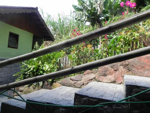 a stairway leading to a garden with flowers at Pousada Solar das Flores Maringá RJ Visconde de Mauá in Visconde De Maua