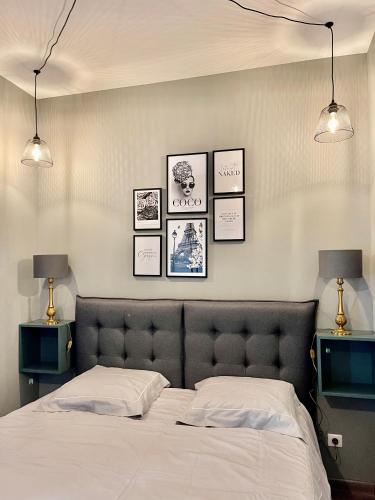 une chambre avec un lit et des tableaux au mur dans l'établissement 3 pièces de rêve à menton, à Menton