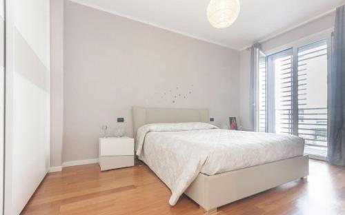 biała sypialnia z łóżkiem i dużym oknem w obiekcie CaseOspitali - Casa La Vela, raffinato bilocale con balcone w mieście Cernusco sul Naviglio