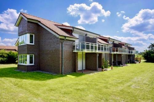 a large brick house with a large yard at Tallskog - Dein Apartment am Naturstrand Hohen Wieschendorf in Hohenkirchen
