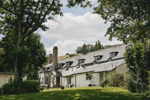 a white house with a gray roof and a yard at Weeke Barton in Exeter