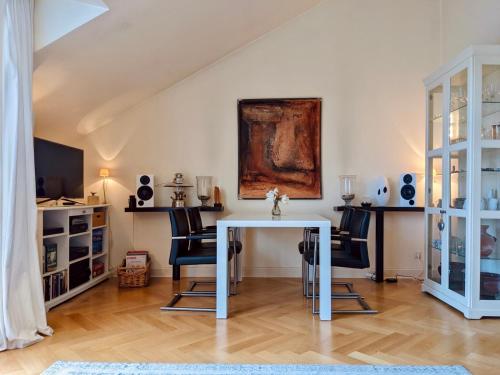 een eetkamer met een witte tafel en stoelen bij Tallskog - Dein Apartment am Naturstrand Hohen Wieschendorf in Hohenkirchen