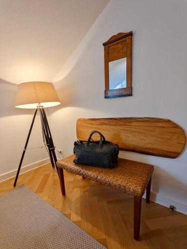a bag sitting on a bench next to a lamp at Tallskog - Dein Apartment am Naturstrand Hohen Wieschendorf in Hohenkirchen
