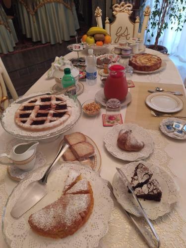 a table topped with pies and pastries on plates at Luxury B&B IL Sogno in Cerignola