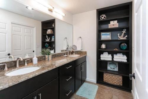 a bathroom with two sinks and a large mirror at Seaside at Anastasia A304 in St. Augustine