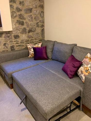 a couch with purple pillows in a living room at Atrani in Santeagueda