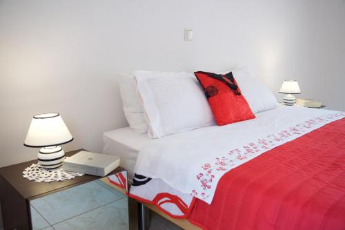 a bedroom with a bed with red and white pillows at Stella's Place in Karavomylos