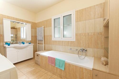 a bathroom with a tub and a sink at Stella's Place in Karavomylos