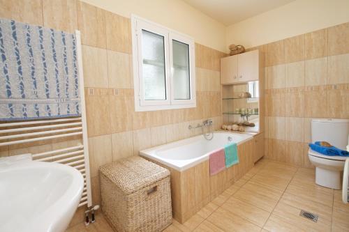 a bathroom with a tub and a sink and a toilet at Stella's Place in Karavomylos