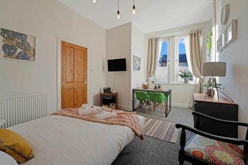 1 dormitorio con cama, escritorio y sofá cama en Cozy with Character Logie Green Central Main Door Flat, en Edimburgo
