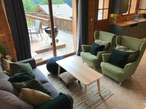 a living room with two couches and a table at Allemond - Restful 2 bed apartment for ski, cycle & family in Allemont