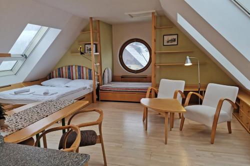 ロキトニツェ・ナト・イゼロウにあるApartmány Rokytniceのベッド、テーブル、椅子が備わる小さな客室です。