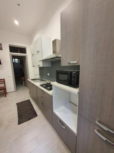 a kitchen with a stove and a microwave at Teatro del Sole Mare Sferracavallo in Palermo