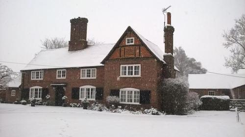 a large brick house with snow on it at One Bedroom cottage retreat Loxley Barn in Tring