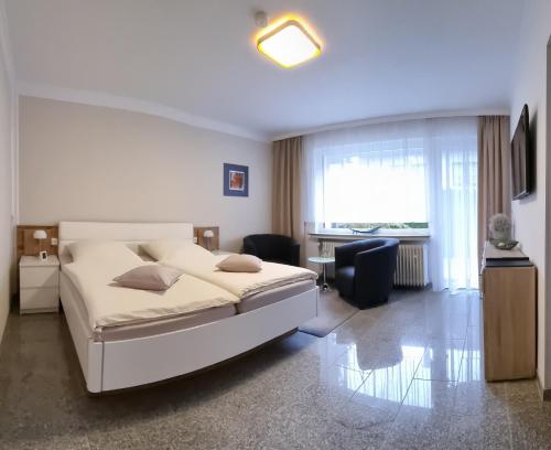 Bonsai-Apartment II في باد بيرمونت: غرفة نوم مع سرير أبيض كبير ومكتب