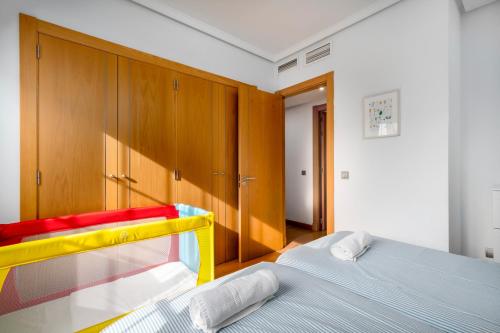 a bedroom with a bed and wooden cabinets at ALAIA PLAYA GRAN TERRAZA by AlohaMalaga in Málaga