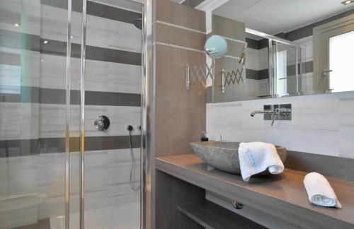 a bathroom with a sink and a glass shower at Drimonari Villas in Agios Nikitas