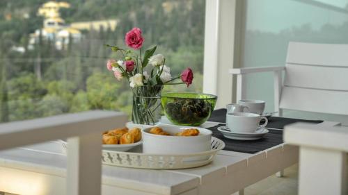 a table with two cups and a vase with flowers at Drimonari Villas in Agios Nikitas