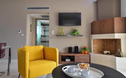 a living room with a yellow chair and a table at Drimonari Villas in Agios Nikitas
