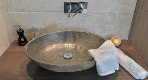 a bathroom with a large stone sink with two towels at Drimonari Villas in Agios Nikitas