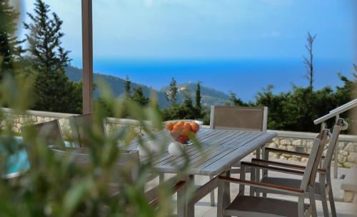 a wooden table with a bowl of fruit on it at Drimonari Villas in Agios Nikitas