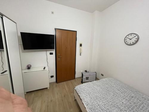 Un dormitorio con una cama y un reloj en la pared. en Casa Vacanza Torino, en Turín