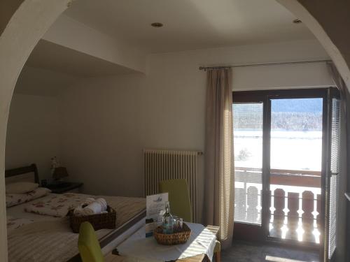 a bedroom with a bed and a large window at Enzianbrenner in Jenig