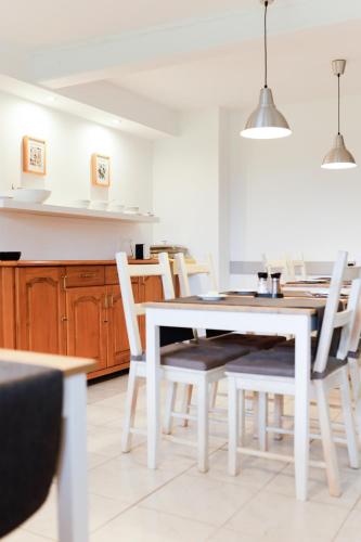 a dining room with a white table and chairs at Willa MM Kaszuby in Łapalice