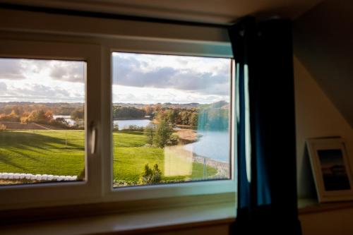 a window with a view of a lake seen through it at Willa MM Kaszuby in Łapalice