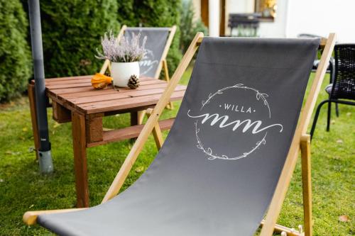 a chair sitting next to a wooden table at Willa MM Kaszuby in Łapalice
