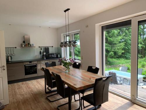 een keuken en eetkamer met een houten tafel en stoelen bij Ferienhaus BB2 in Bad Brambach