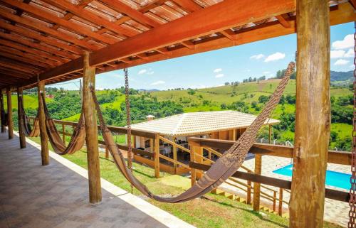een veranda met een hangmat en een zwembad bij NOVO Incrível chácara com WiFi em Socorro SP in Socorro