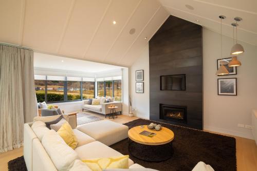 a living room with a white couch and a fireplace at Millbrook Resort in Arrowtown