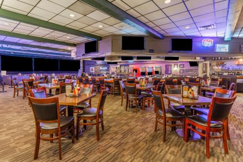 a dining room with tables and chairs and televisions at Holiday Inn Rockford by IHG in Rockford
