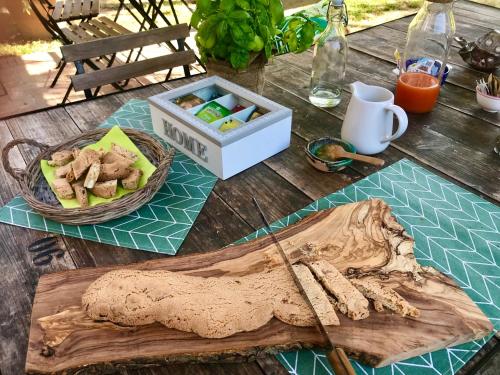 a wooden table with a wooden cutting board and a box of food at Il Cantuccio in Cascina