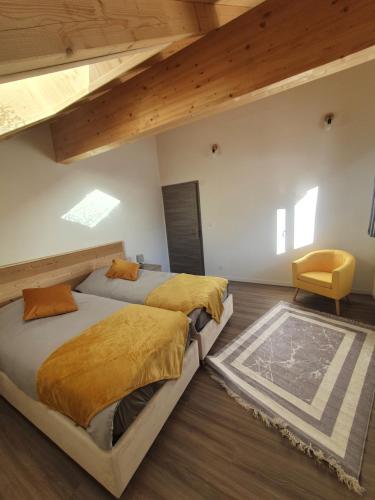 2 Betten in einem Schlafzimmer mit Holzdecken und Holzböden in der Unterkunft Maison au cœur de l'Oisans in Armentier Haut