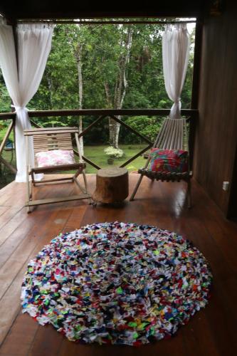a large rug on a wooden floor in a room at Sítio Pássaro Ímpar - Para pousar e repousar in Curuçá