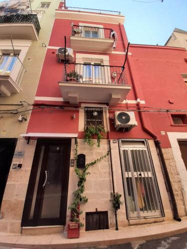 czerwony budynek z balkonem na ulicy w obiekcie Il Cavalliere Bed & breakfast w mieście Barletta