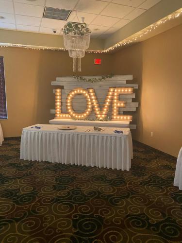 a sign that says love on a table in a room at Cobblestone Hotel & Suites - Broken Bow in Broken Bow