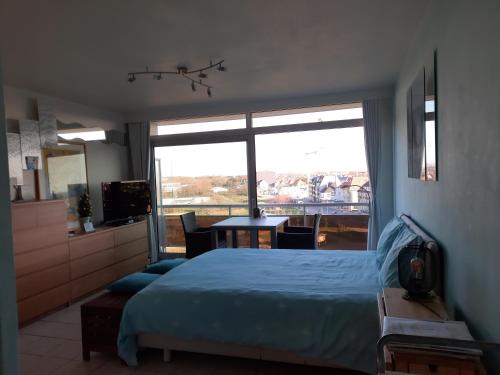 a bedroom with a bed and a large window at Studio with sea view and panoramic view in Bredene in Bredene