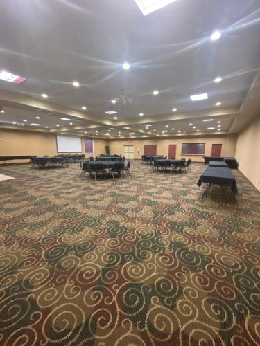 a large room with tables on a carpet at Cobblestone Hotel & Suites - Broken Bow in Broken Bow