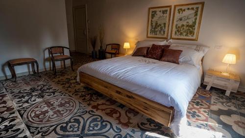 a bedroom with a large bed and two chairs at Locanda Dell'Oleificio in Mezzane di Sotto