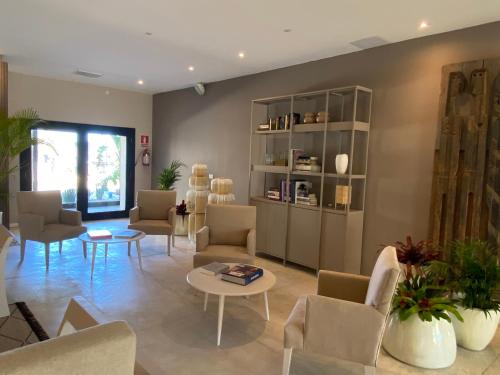a living room with chairs and tables and a book shelf at Serena Hotel - Punta del Este - Unico sobre la Playa in Punta del Este