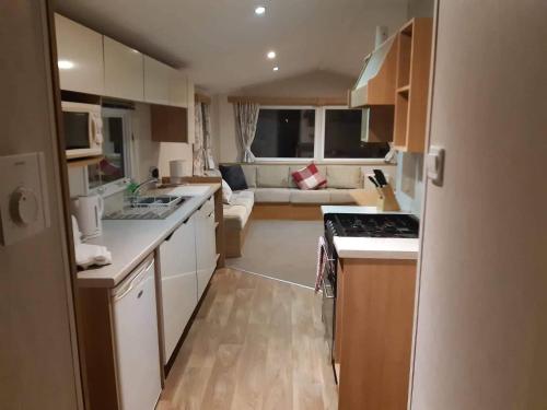 a small kitchen with a stove and a couch at 58 Newquay View, Newquay Bay Resort in Newquay Bay Resort