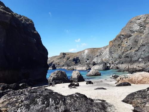 a beach with rocks in the water and a blue sky at 58 Newquay View, Newquay Bay Resort in Newquay Bay Resort