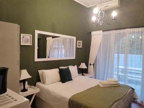 a bedroom with a bed with a mirror and a window at Bono Luxury Guesthouse in Rustenburg